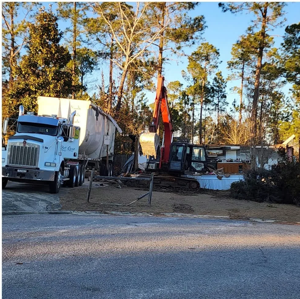 Kenworth dump truck and excavator tearing down a mobile home